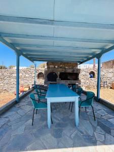 a blue table and chairs on a patio with a fireplace at Olive House in Márpissa