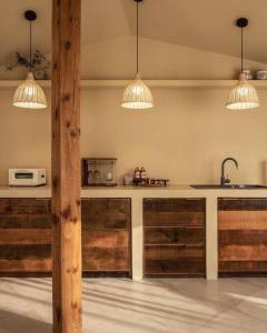 eine Küche mit Holzschränken und zwei Hängelampen in der Unterkunft Gamsanchagyung in Seogwipo