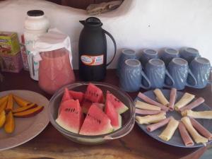 uma mesa com uma taça de fruta e um prato de comida em Pousada Cavallitos d'Amar na Ilha de Boipeba