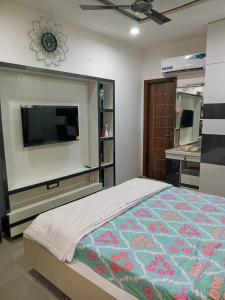 a bedroom with a bed and a flat screen tv at The Great Escape - Rustic Countryside Stay in Amritsar