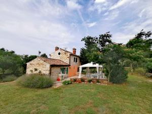 an old house with a gazebo in a field at Cottage Casa Vinela in Buje +29 photos