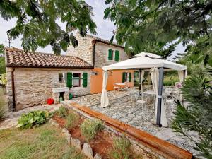 an external view of a house with an umbrella at Cottage Casa Vinela in Buje