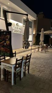 a group of tables and umbrellas in front of a building at Tuck Inn in Larnaca