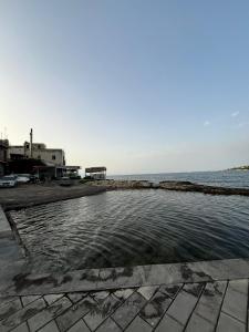 a pool of water next to the ocean at Trinacrie Home's in Brucoli +4 photos
