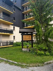 a sign in the grass in front of a building at Studio au cœur de la station de Risoul 1850 in Risoul +4 photos