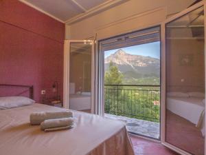 a bedroom with a balcony with a view of a mountain at VistaTzoumerka in Ágnanta