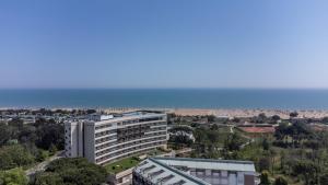 a large white building with the ocean in the background at Laguna Park Hotel 4Superior in Bibione
