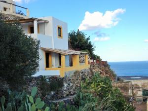 a house on a hill with the ocean in the background at Casa al Vallone in Alicudi