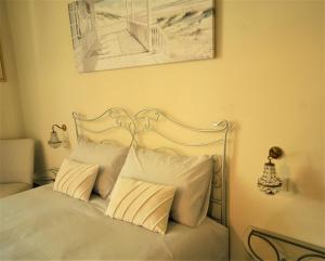 a white bed with white pillows and a picture on the wall at Villa Gemma in Ravenna
