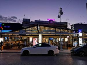 a white car parked in front of a store at Tuck Inn in Larnaca