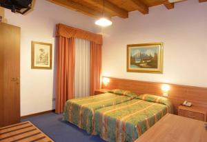 a hotel room with a bed and a table at Hotel Da Bepi in Lido di Jesolo