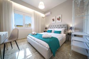 een slaapkamer met een bed, een bureau en een raam bij Akalli Luxury Living in Heraklion