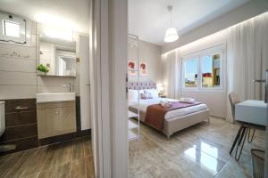 een slaapkamer met een bed en een badkamer met een wastafel bij Akalli Luxury Living in Heraklion
