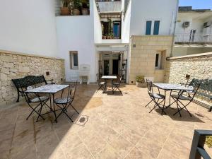 a patio with tables and chairs and a building at Dimora Carafa apartment in Lecce +70 photos