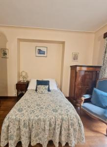 a bedroom with a bed and a blue chair at Maison atypique in Tende +6 photos
