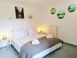 a bedroom with a large bed with two towels at Seeblickapartment für bis zu 12, Nürnberg & Schwabach in 30-35 Minuten zu erreichen, Sauna, Arbeitsplatz, Dachterrasse & Grill in Spalt