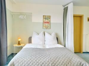 a bedroom with a large bed with white pillows at Seeblickapartment für bis zu 12, Nürnberg & Schwabach in 30-35 Minuten zu erreichen, Sauna, Arbeitsplatz, Dachterrasse & Grill in Spalt +31 photos