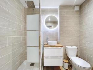 a bathroom with a toilet and a sink and a mirror at La petite boétie in Sarlat-la-Canéda