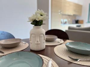 a table with plates and a vase with flowers in it at Apartment Aleks in Tar