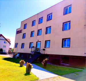 a large building with blue windows on the side of it at Korsarz in Łeba