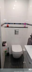 a bathroom with a white toilet and a sink at Le Studio in Aubervilliers