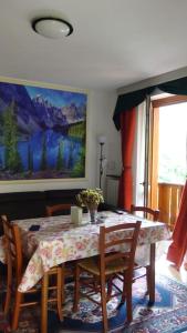 a dining room with a table with chairs and a painting at Chalet Belvedere in Costa di Serina