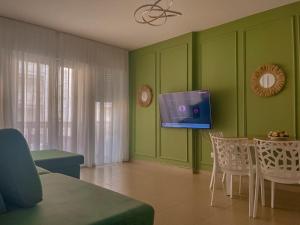 a living room with green walls and a tv at Apartament REJ VELIPOJE in Velipojë