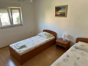 a small bedroom with two beds and a window at Apartments Jita in Primošten