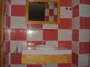 Łazienka z umywalką oraz czerwonymi i białymi kafelkami w obiekcie DownTown Guest House w Lizbonie