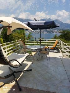 a patio with a table and chairs and an umbrella at Apartmani "Srma" Srma 1 in Herceg-Novi