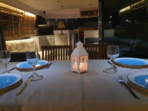 a table with plates and glasses and a lantern on it at Yacht ZEN in Heraklio
