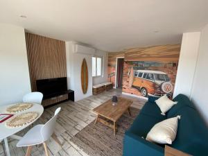 Una sala de estar con un sofá azul y una mesa. en Appartement Océane terrasse panoramique, en Saint-Palais-sur-Mer