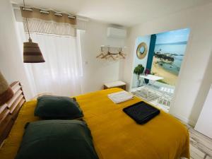 Un dormitorio con una cama amarilla con vistas a la playa. en Appartement Océane terrasse panoramique, en Saint-Palais-sur-Mer