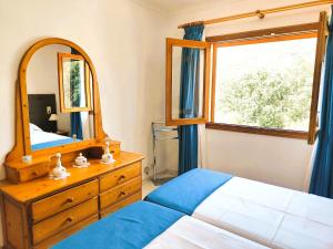 a bedroom with a mirror and a bed and a dresser at Villa Capllonch in Banyalbufar