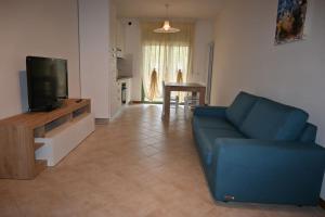 a living room with a blue couch and a television at Fontana Apartment in Perugia