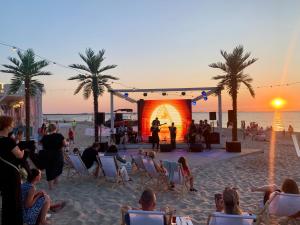 Un grupo de personas sentadas en una playa con un escenario. en Blue Reef 6th Floor Sea View, en Międzyzdroje 47 fotos más