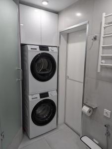 un lavadero con lavadora y secadora en Moonflower residence 4645, en Bishkek