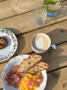 卡尔康Camping la Kahute - Tente tipi au coeur de la fôret的餐桌,早餐盘和咖啡