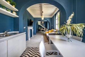 a kitchen with blue walls and a table with a plant at Luxury Limonaia with Jacuzzi near Florence in San Jacopo al Girone