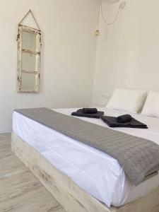 a white bed with two towels on top of it at Gaia - TCupStudios in Kythira
