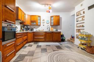 a large kitchen with wooden cabinets and a tile floor at DOM 4 SEZONY in Osłonin
