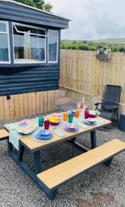 a picnic table with plates of food on it at Mobile Holiday Home in Cushendall