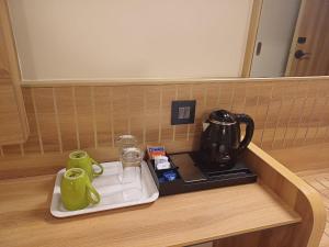 Příslušenství pro přípravu čaje a kávy v ubytování Hotel Raai Hosur