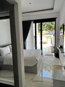 Schlafzimmer mit einem Bett und Blick auf einen Innenhof in der Unterkunft Ramana Villa Uluwatu in Uluwatu