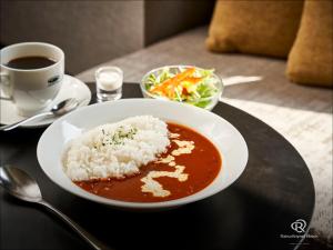 a bowl of soup with rice and a cup of coffee at Daiwa Roynet Hotel Osaka Sakaisuji Honmachi PREMIER in Osaka