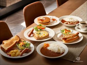 a table with plates of breakfast food on it at Daiwa Roynet Hotel Osaka Sakaisuji Honmachi PREMIER in Osaka +41 photos