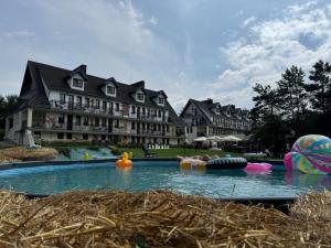 a pool in front of a large building at Końska Dolina in Krynica Zdrój