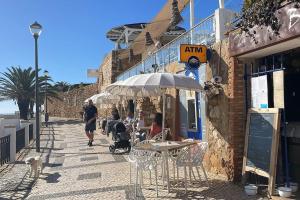 un gruppo di persone sedute a un tavolo sotto un ombrello di Casa Dolce Farniente a Luz