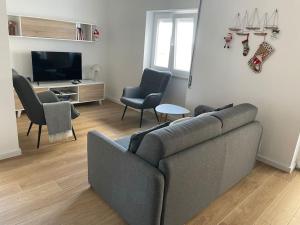 un soggiorno con divano, sedie e TV di Casa Dolce Farniente a Luz