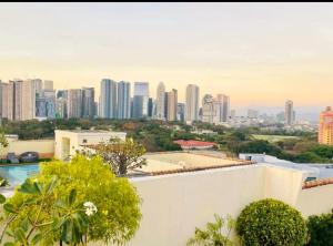 a view of a city skyline from a building at Cozy Corner Haven near Venice Grand Canal Mall in Manila